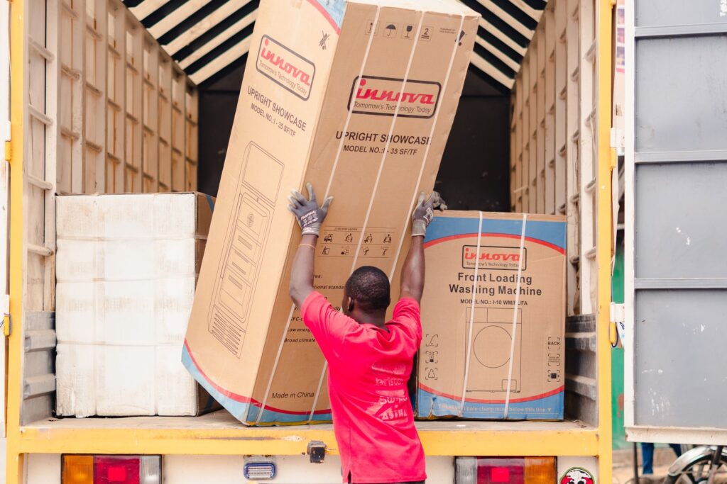 house movers Red Hill Kiambu - Movers carrying furniture into a bright, modern apartment building