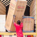 house movers Red Hill Kiambu - Movers carrying furniture into a bright, modern apartment building
